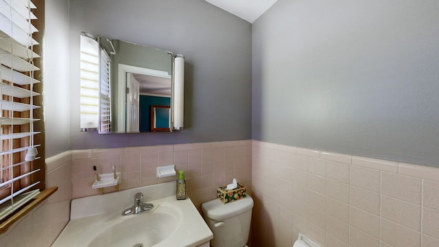 bathroom featuring vanity, toilet, and tile walls