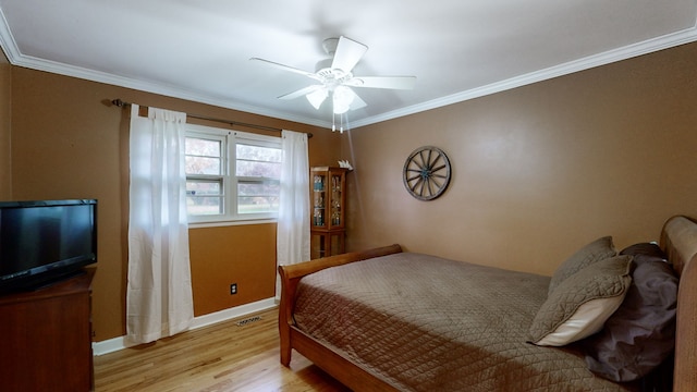 bedroom with ceiling fan, ornamental molding, and light wood-type flooring