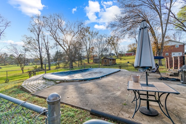 view of pool featuring a shed, a patio area, and a lawn