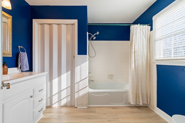 bathroom featuring hardwood / wood-style flooring, vanity, and shower / tub combo with curtain