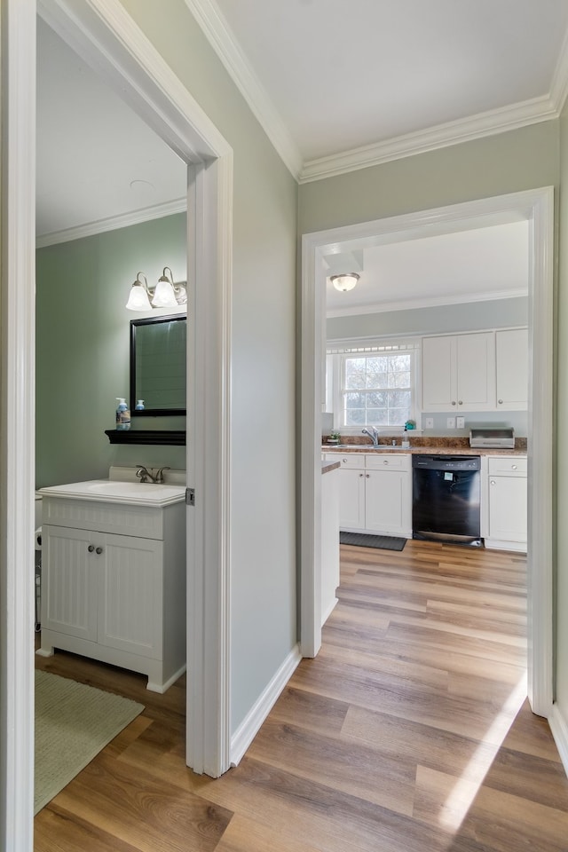 hall with sink, ornamental molding, and light wood-type flooring