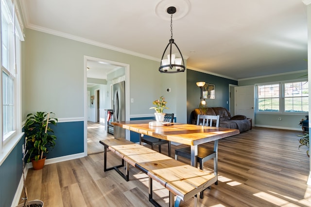 dining space with ornamental molding and hardwood / wood-style floors