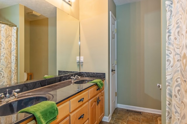 bathroom featuring vanity, a textured ceiling, and toilet