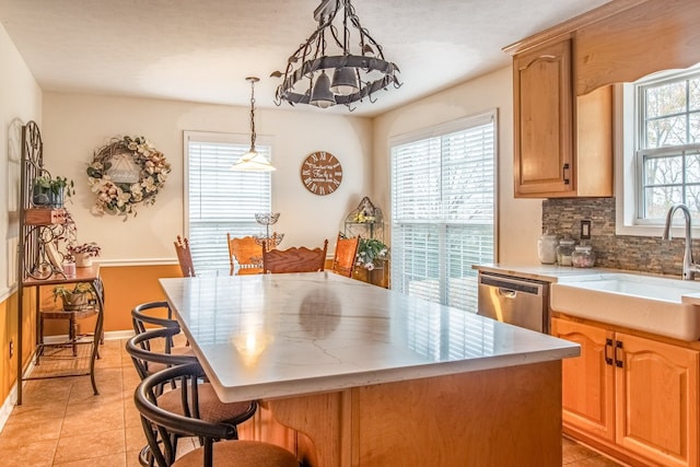 kitchen featuring dishwasher, a center island, a wealth of natural light, and sink