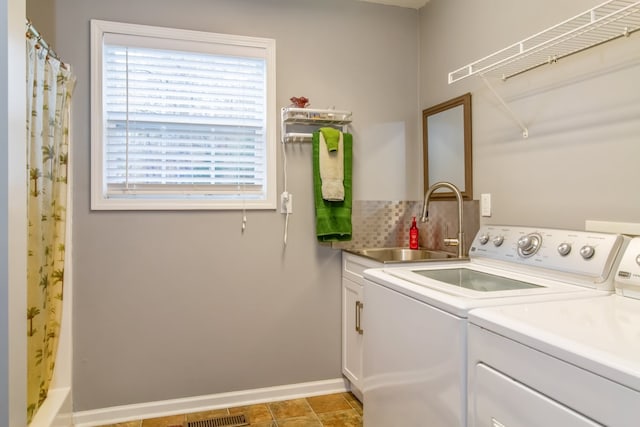 laundry room with cabinets, sink, and washer and dryer