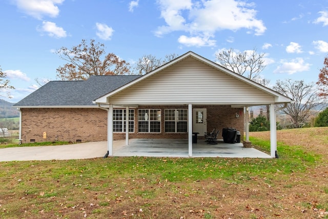 rear view of house featuring a yard and a patio