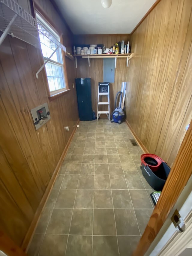 laundry room with wooden walls, tile patterned flooring, and washer hookup