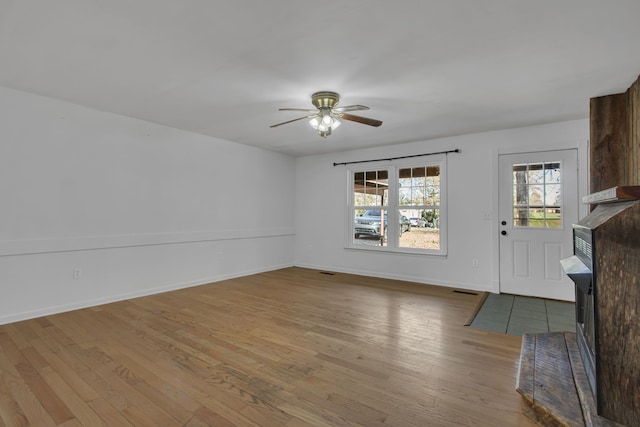 unfurnished living room with ceiling fan and light hardwood / wood-style floors