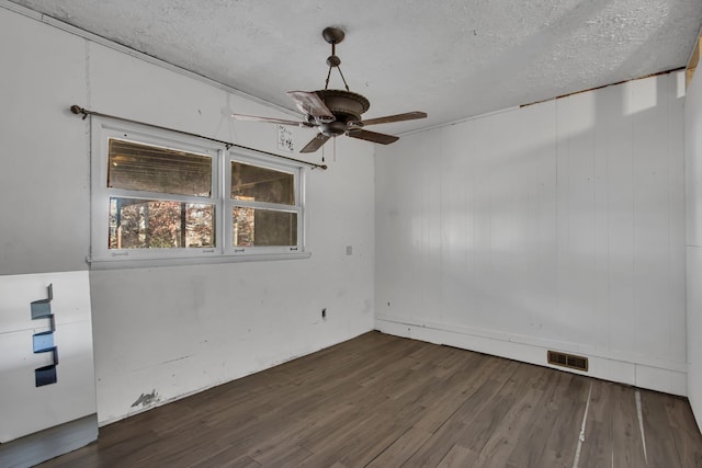 spare room with a textured ceiling, ceiling fan, and dark hardwood / wood-style floors