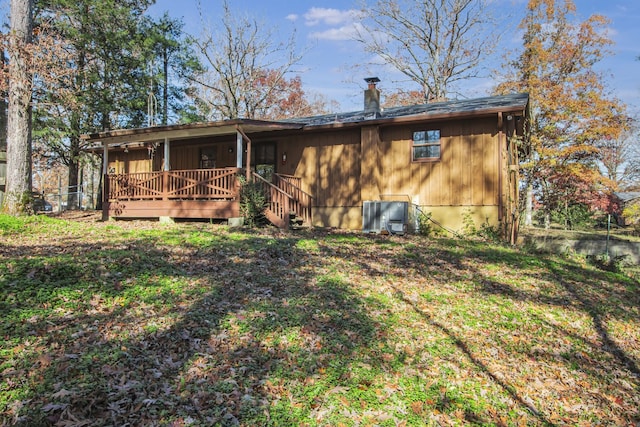 back of property featuring a lawn and a wooden deck