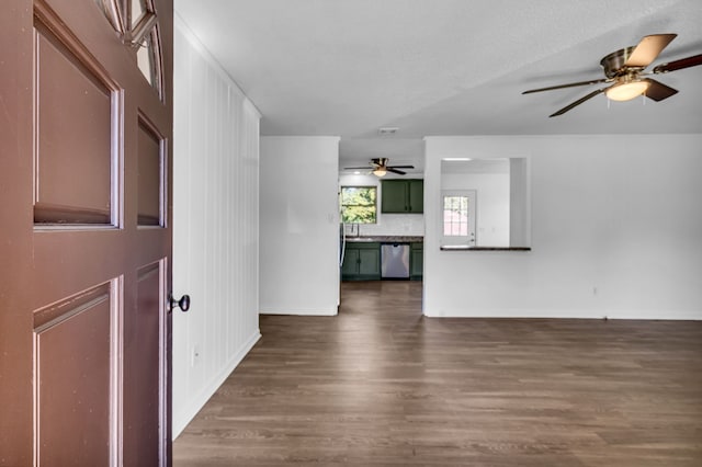 unfurnished living room featuring ceiling fan, sink, and dark hardwood / wood-style floors