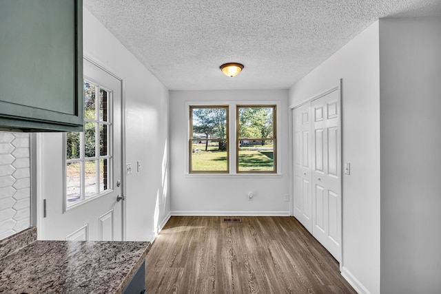 interior space featuring a textured ceiling and dark hardwood / wood-style floors