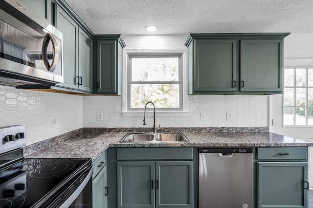 kitchen featuring decorative backsplash, a wealth of natural light, sink, and appliances with stainless steel finishes