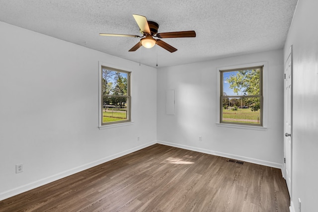 empty room featuring ceiling fan, dark hardwood / wood-style flooring, and a textured ceiling