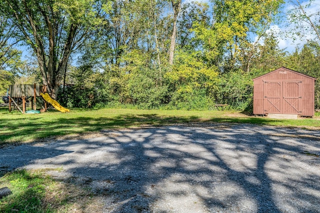 view of yard with a playground and a storage shed