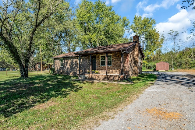 ranch-style home with a front lawn and a storage unit