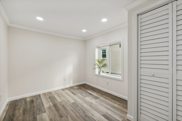 spare room featuring light wood-type flooring and ornamental molding