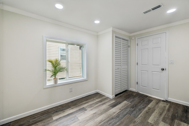 unfurnished bedroom with crown molding, a closet, and dark wood-type flooring