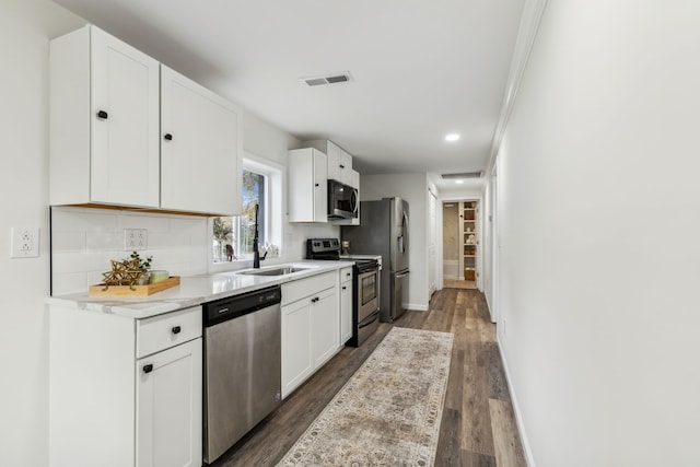 kitchen featuring sink, dark hardwood / wood-style flooring, appliances with stainless steel finishes, white cabinets, and ornamental molding