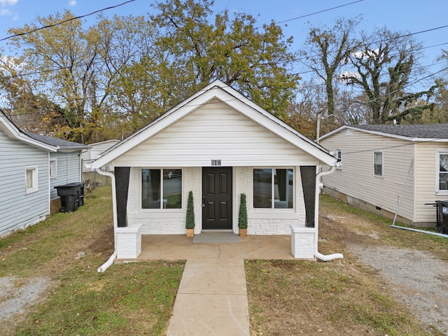 bungalow-style home with a front yard