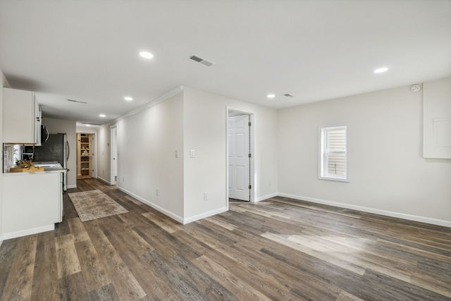 unfurnished living room featuring dark hardwood / wood-style floors and ornamental molding