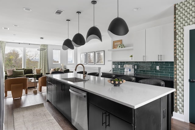 kitchen featuring white cabinetry, a kitchen island with sink, sink, and stainless steel dishwasher