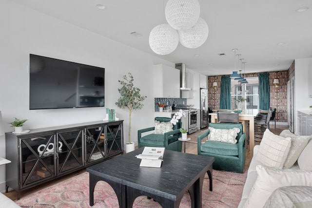 living room with a chandelier and light hardwood / wood-style floors