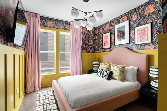 bedroom featuring a notable chandelier, multiple windows, and light hardwood / wood-style flooring