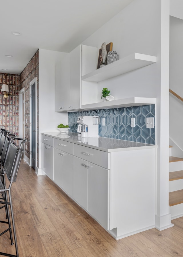 kitchen featuring tasteful backsplash, white cabinetry, and light hardwood / wood-style flooring