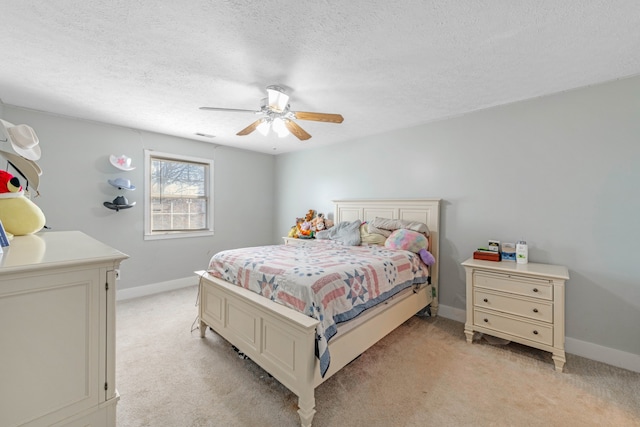 carpeted bedroom featuring ceiling fan and a textured ceiling