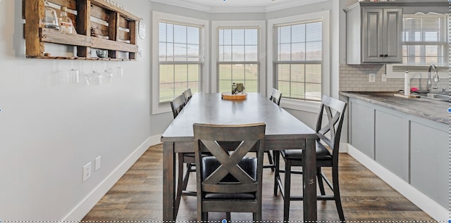 dining area with a healthy amount of sunlight, dark wood-type flooring, and ornamental molding