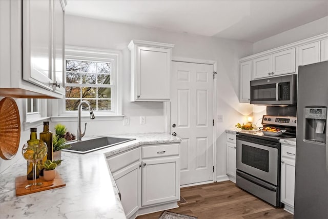 kitchen featuring white cabinets, sink, stainless steel appliances, and dark wood-type flooring