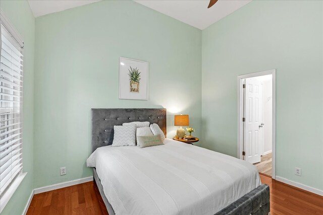 bedroom with hardwood / wood-style flooring, ceiling fan, and lofted ceiling