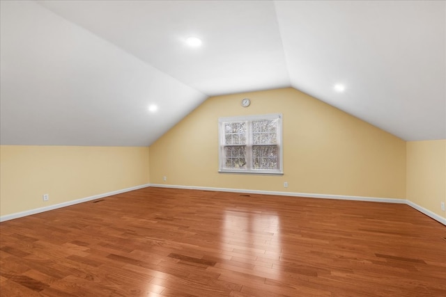 additional living space featuring hardwood / wood-style floors and vaulted ceiling