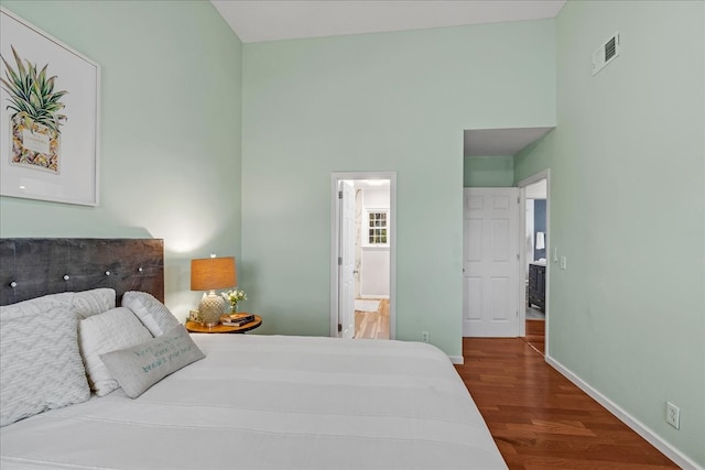 bedroom with hardwood / wood-style floors and ensuite bathroom