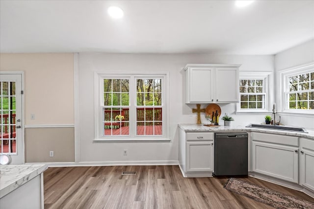 kitchen featuring white cabinets, light wood-type flooring, black dishwasher, and sink