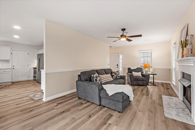 living room featuring ceiling fan and light hardwood / wood-style flooring