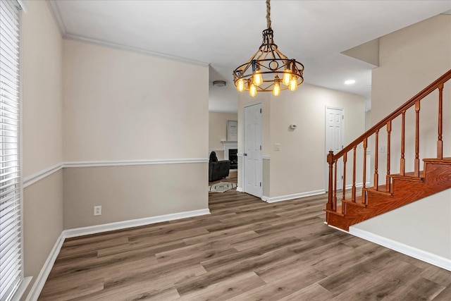 interior space featuring a chandelier, hardwood / wood-style flooring, and crown molding