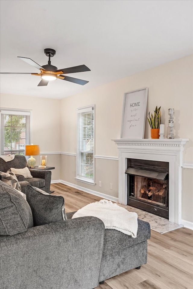 living room with ceiling fan and light hardwood / wood-style flooring