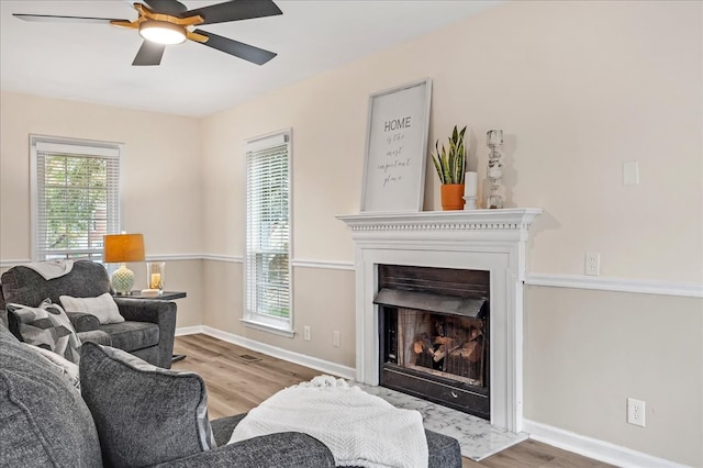 living room with light hardwood / wood-style flooring and ceiling fan