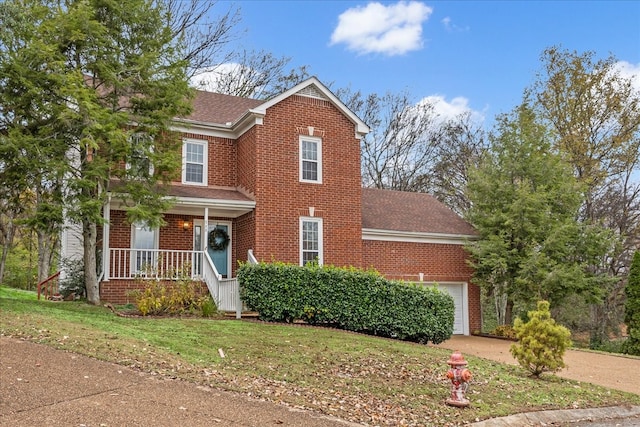 view of front of home with a front yard, a porch, and a garage