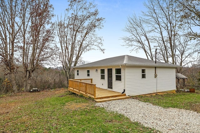 rear view of property with a lawn and a deck