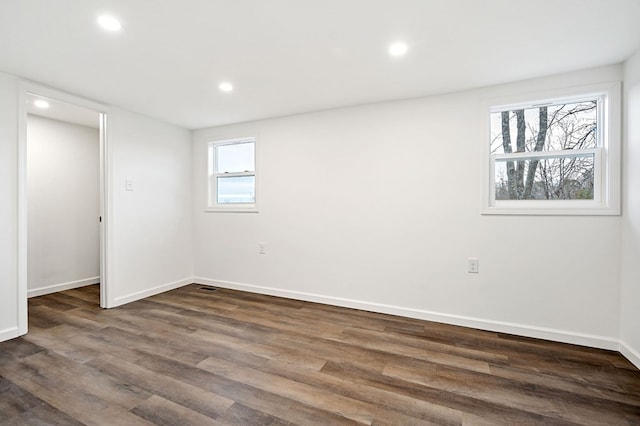 unfurnished room with dark hardwood / wood-style flooring and a wealth of natural light