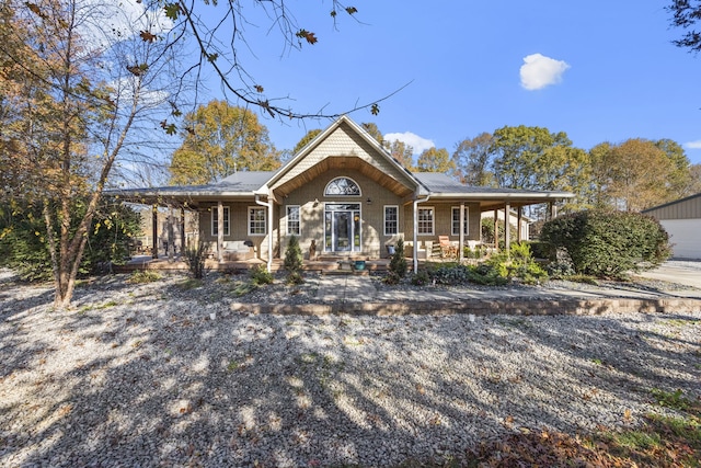 view of front of home with a porch, a garage, and an outbuilding