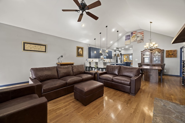 living room featuring wood-type flooring, ceiling fan with notable chandelier, and vaulted ceiling