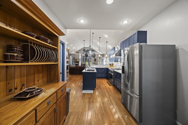 kitchen with wall chimney exhaust hood, stainless steel appliances, pendant lighting, light hardwood / wood-style flooring, and lofted ceiling