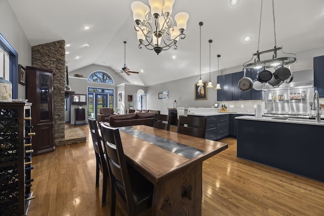 kitchen featuring blue cabinetry, pendant lighting, a kitchen island, ceiling fan with notable chandelier, and hardwood / wood-style flooring