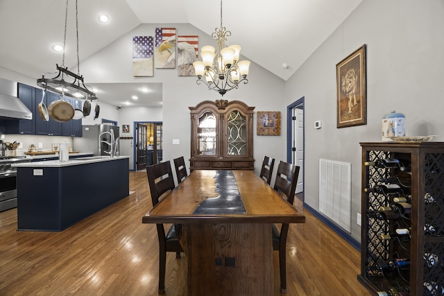 dining room featuring high vaulted ceiling, wood-type flooring, and a notable chandelier