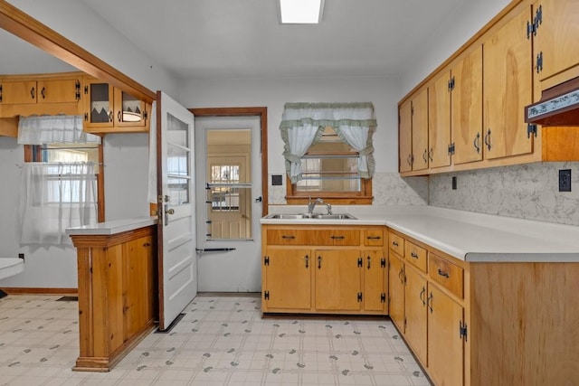 kitchen with kitchen peninsula, sink, and exhaust hood