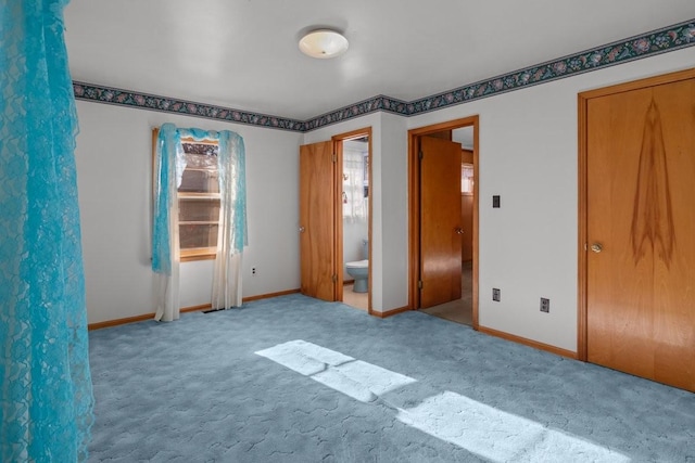 unfurnished bedroom with light colored carpet and connected bathroom